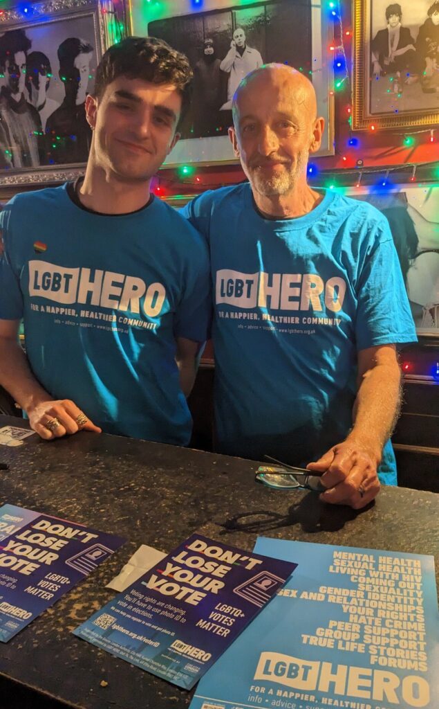 Two men wearing LGBT Hero t-shirts raising awareness of photo ID needed to vote and offering support for those who need to apply for photo ID