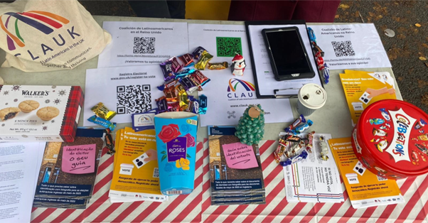 A table covered in information leaflets and chocolates.