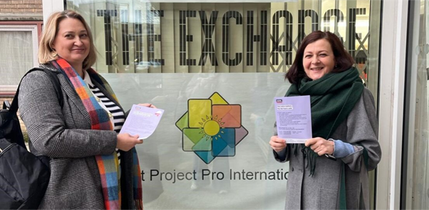 Two women holding information leaflets.