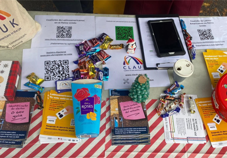 A table covered in information leaflets and chocolates.