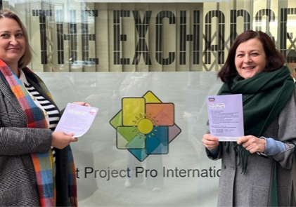 Two women holding information leaflets.