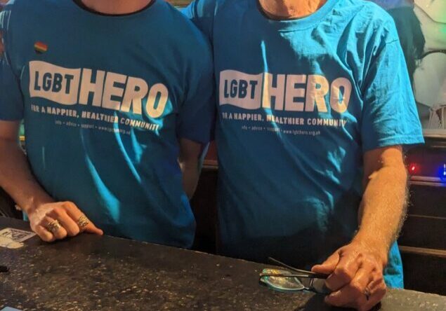 Two men wearing LGBT Hero t-shirts raising awareness of photo ID needed to vote and offering support for those who need to apply for photo ID